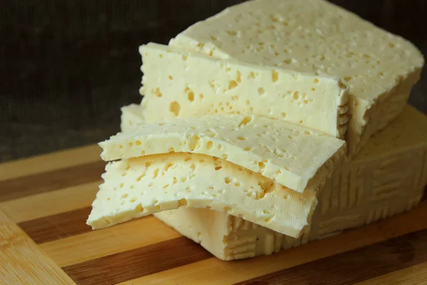 Formaggio casereccio, tagliato a pezzi sulla tavola — Foto Stock