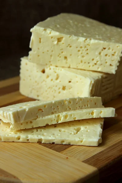 Queso casero, cortado en trozos en el tablero — Foto de Stock