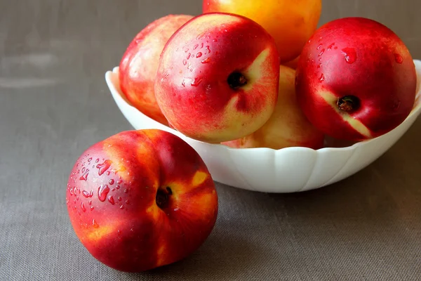 Ripe nectarines in a bowl on the table — Stock Photo, Image