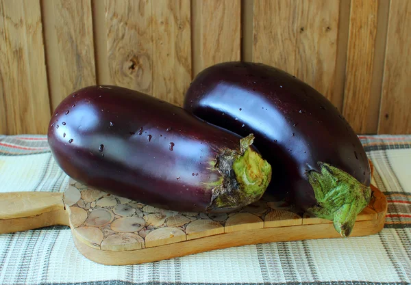 Två aubergine på en svart tavla — Stockfoto