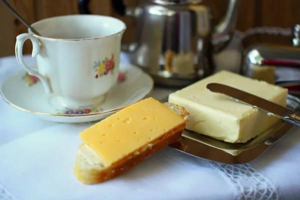 Panino con una fetta di formaggio e una tazza di tè a colazione — Foto Stock