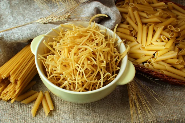 Nudeln im Teller und Spaghetti auf dem Tisch — Stockfoto