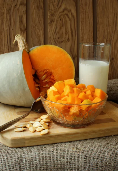 Pumpkin, diced for cooking recipe and a glass of milk — Stock Photo, Image