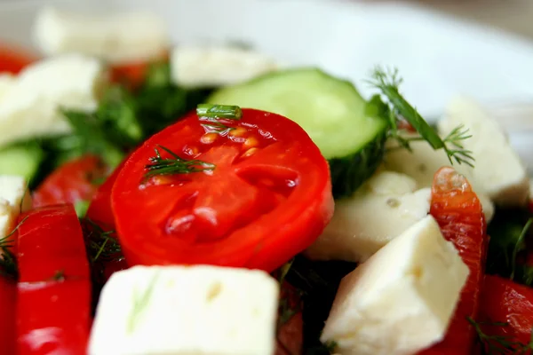 Tomatoes, cucumbers and feta cheese in a salad closeup — Stock Photo, Image