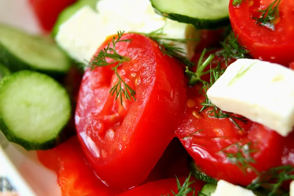 Tomatoes, cucumbers and feta cheese in a salad closeup — Stock Photo, Image