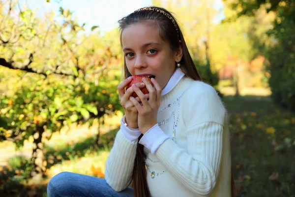 Niedliches kleines Mädchen beißt in einen reifen Apfel — Stockfoto