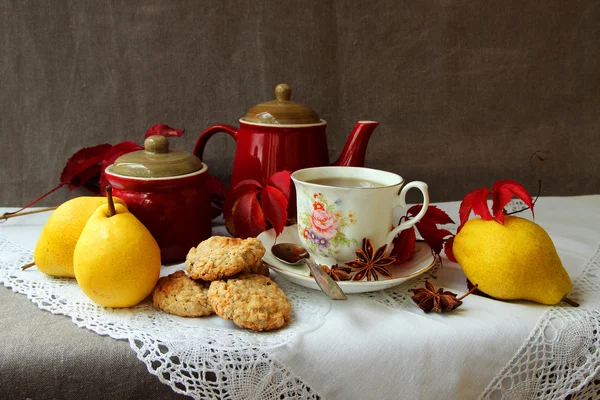 Nature morte avec une tasse de thé chaud, des biscuits à l'avoine et des poires — Photo