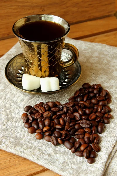 Taza de café y granos de café en forma de corazón — Foto de Stock