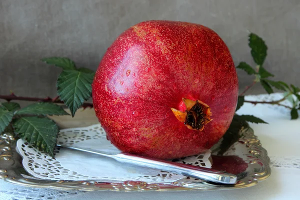 Ripe pomegranate on a plate — Stock Photo, Image