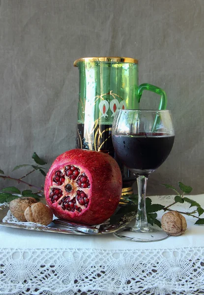 Stillleben mit einem Granatapfel, einem Glas Wein und einem Krug — Stockfoto