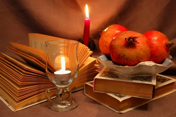 Still life with pomegranates and candle — Stock Photo, Image