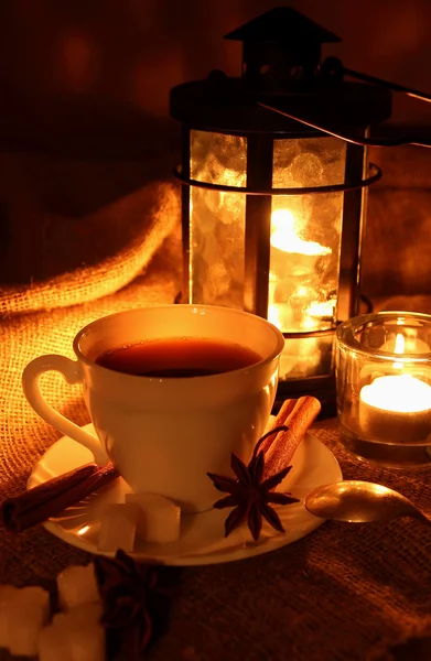 Una taza de café caliente sobre un fondo de una antorcha ardiente —  Fotos de Stock