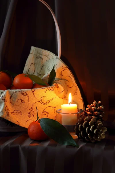 Mandarins in a basket and candle — Stock Photo, Image