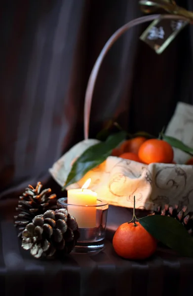 Mandarins em uma cesta e vela — Fotografia de Stock