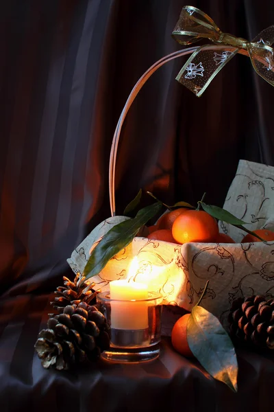 Mandarins in a basket and candle — Stock Photo, Image