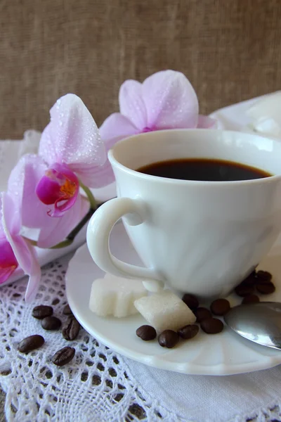 Cup of coffee and a branch of orchid — Stock Photo, Image