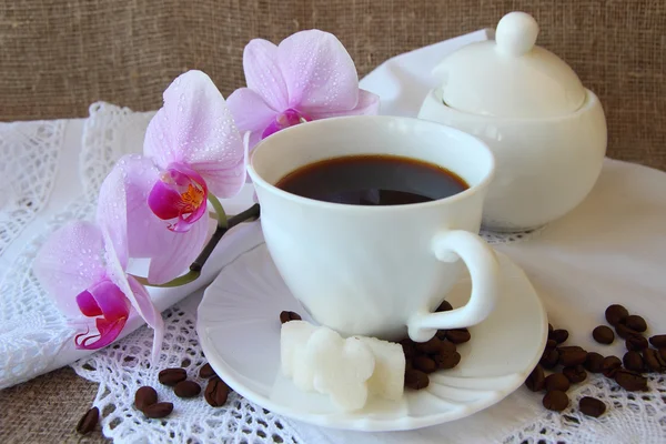 Xícara de café e um ramo de orquídea — Fotografia de Stock