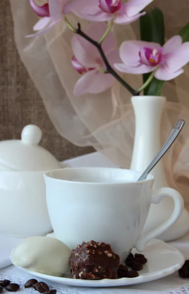 Una tazza di caffè, caramelle e orchidea di ramo — Foto Stock