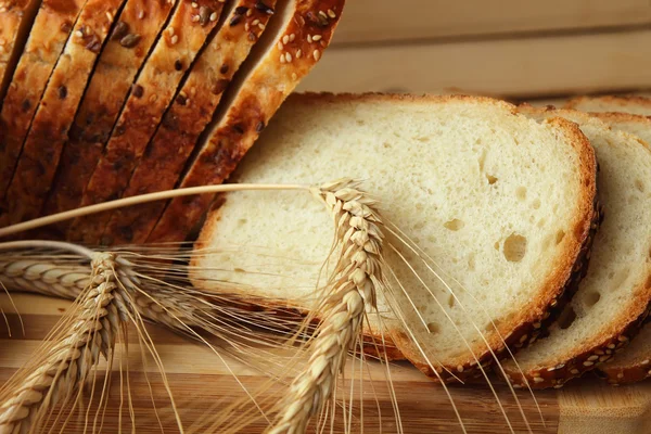 Skivad hembakade bröd och vete öron — Stockfoto