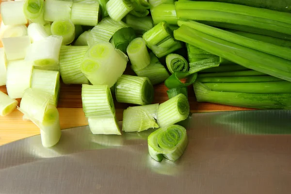Cipolle verdi, tagliate a fette sulla tavola — Foto Stock