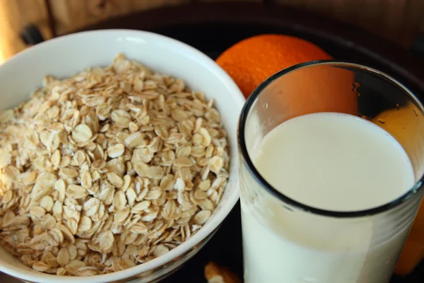 Bicchiere di latte e un piatto di farina d'avena — Foto Stock