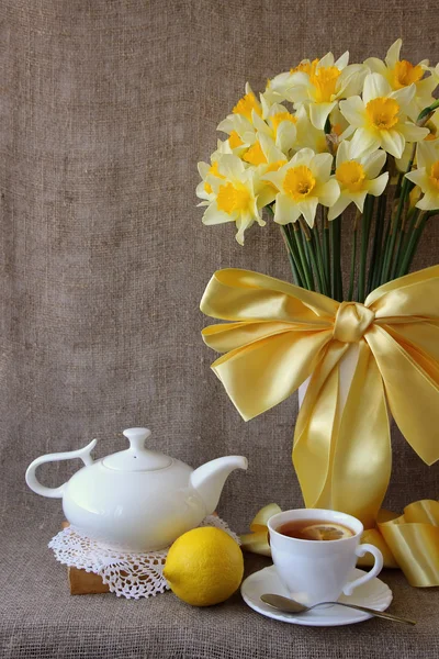 Eine Tasse Tee und ein Strauß Narzissen — Stockfoto