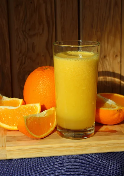 Un vaso de jugo de naranja y rodajas de naranja — Foto de Stock