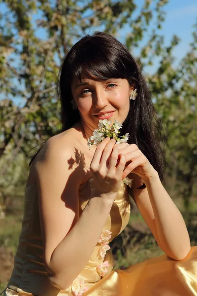 Mooi meisje op de achtergrond van een bloeiende tuin — Stockfoto