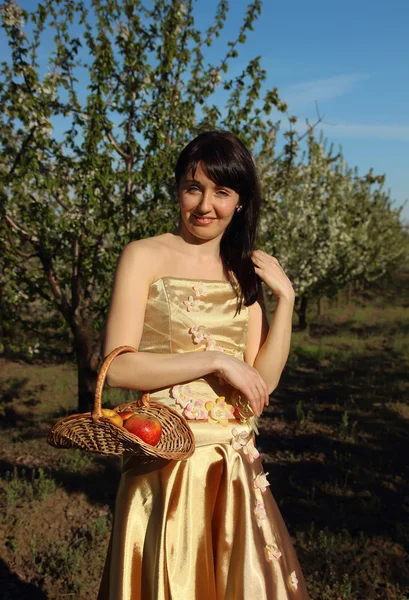 Hermosa chica con una cesta en las manos en el fondo de la naturaleza —  Fotos de Stock