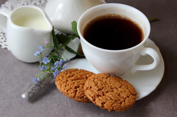 En kopp kaffe, vårblommor och havremjöl kakor — Stockfoto