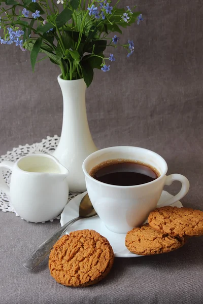 En kopp kaffe, vårblommor och havremjöl kakor — Stockfoto