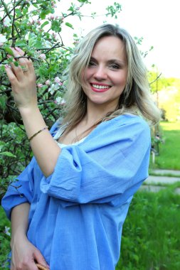 Güzel kız çiçek açan elma ağacının yanında ayakta