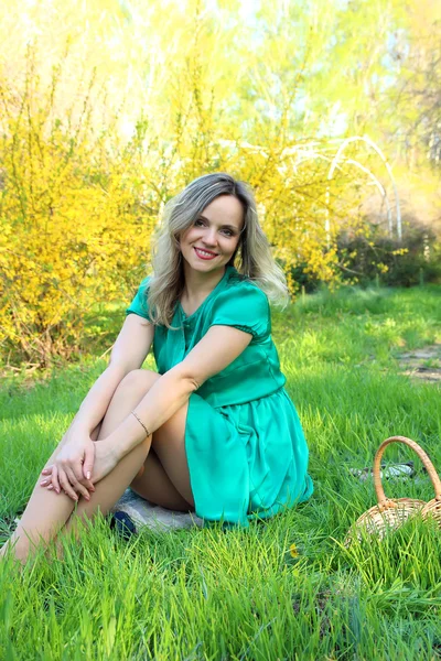 Beautiful girl sitting on the green lawn — Stock Photo, Image