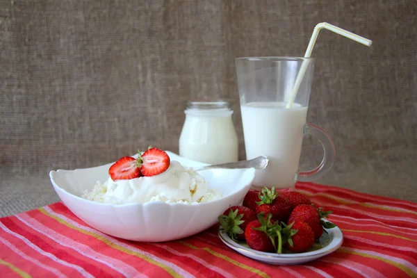 Fat med keso med grädde och jordgubbar och ett glas mjölk — Stockfoto