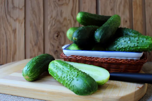 Cucumbers, lying on a board for the preparation of salad — Stock Photo, Image
