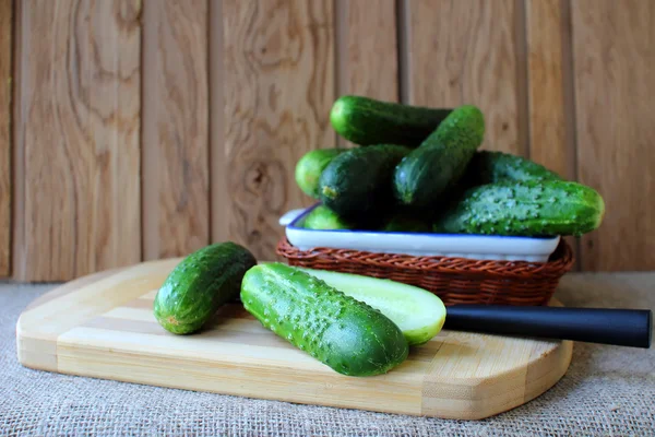 Pepinos, deitados em um tabuleiro para a preparação de salada — Fotografia de Stock