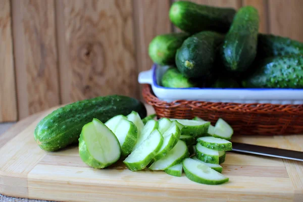 Komkommers, liggend op een bord en knip voor salade — Stockfoto