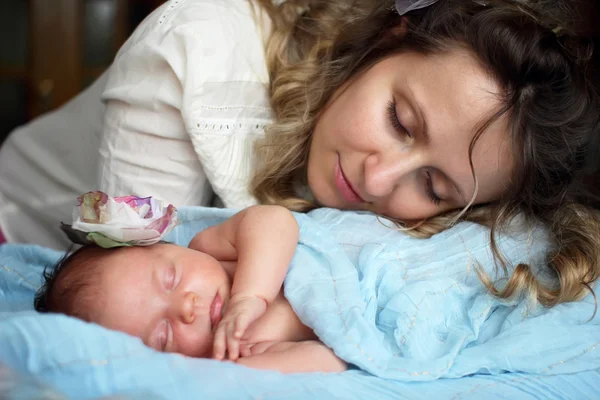 Bebek annesiyle küçük yatağında uyuyor