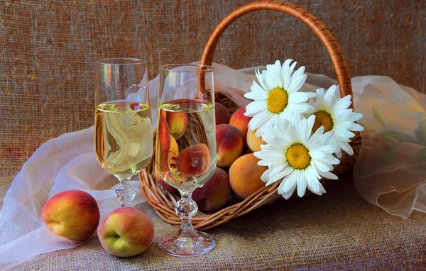 Dos copas de vino blanco, duraznos y un ramo de margaritas —  Fotos de Stock