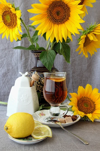 Tasse de thé, citron et un bouquet de tournesols — Photo