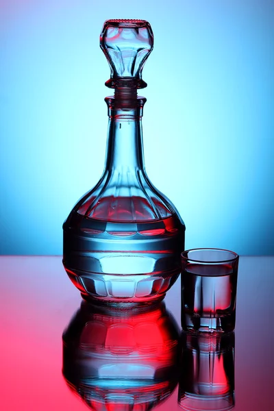 Dekanter mit Wodka auf blauem Hintergrund — Stockfoto