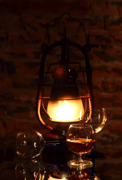 Cognac in a glass on a background of lantern — Stock Photo, Image