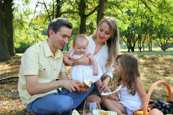 Pai cortou o melão para seus filhos e esposas em um piquenique . — Fotografia de Stock