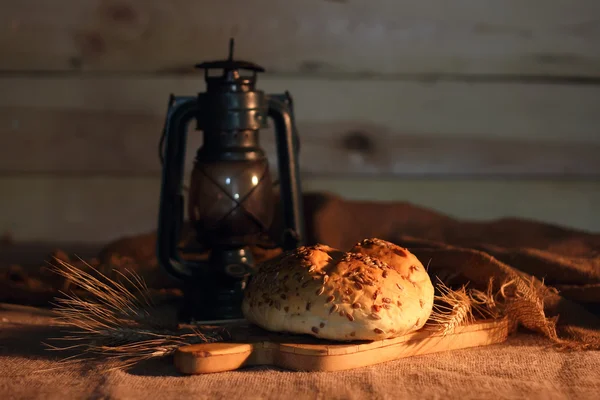 Pane fresco di pane fatto in casa sullo sfondo di una lanterna . — Foto Stock