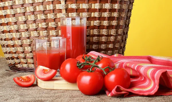 El jugo de tomate se vierte en vasos y tomates maduros . — Foto de Stock
