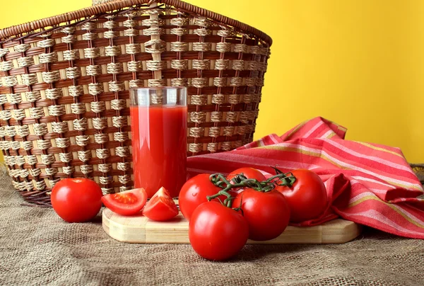 Un vaso de jugo de tomate y tomates maduros . —  Fotos de Stock