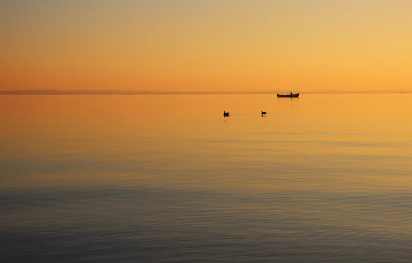 Beautiful sunset on the background of the water surface of the lake. — Stock Photo, Image