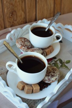 İki bardak kahve ve kek bir tepsi.