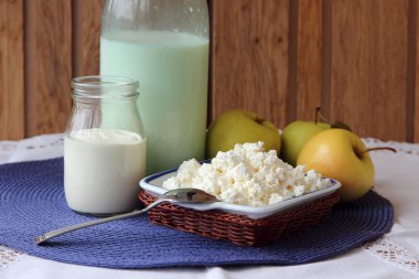 Süzme peynir, bir şişe süt ve meyve tabağı.