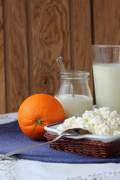 Dish of cottage cheese, a bottle of milk and fruits. — Stock Photo, Image